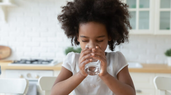 Thirsty,Little,African,American,Kid,Feel,Dehydrated,Enjoy,Clean,Mineral Photo of an african-american child sitting down and drinking a glass of water.